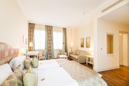 a hotel room with a large bed and a living room at Rheinhotel Schulz in Unkel