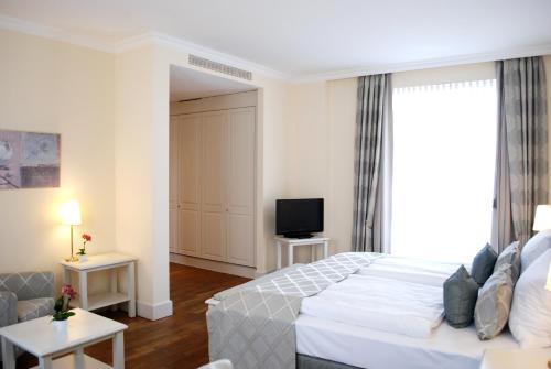 a hotel room with a bed and a television at Rheinhotel Schulz in Unkel