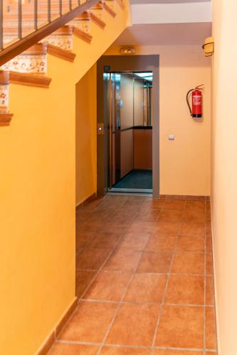 a hallway with yellow walls and tile floors at Apartamento Duplex Puente de Piedra, en un enclave único y exclusivo in Valderrobres