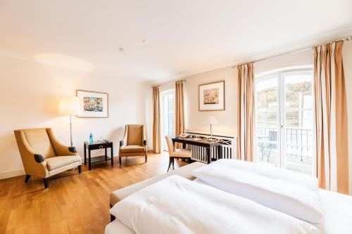 ウンケルにあるRheinhotel Schulzのベッドとデスクが備わるホテルルームです。