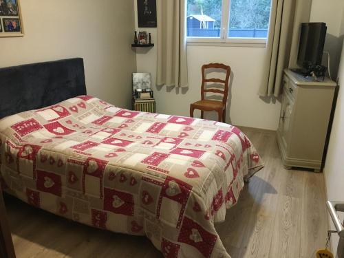 - une chambre avec un lit doté d'une couette rouge et blanche dans l'établissement Au Vieux Bourg, à Guécélard
