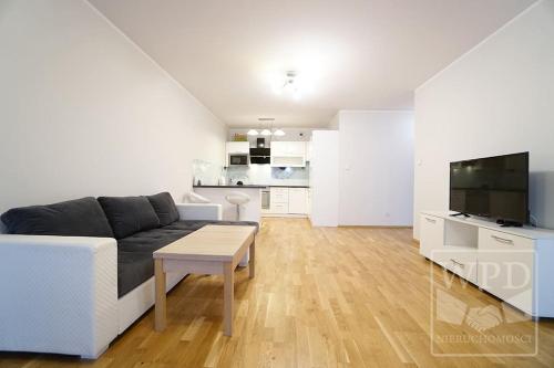 a white living room with a couch and a table at Modern Apartment-City Center-New Building-Garage in Wrocław