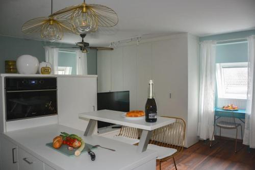 cocina con mesa y botella de vino en moderne Ferienwohnung, en Merano