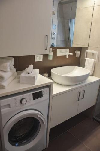 a bathroom with a washing machine and a sink at moderne Ferienwohnung in Merano