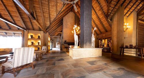 a large room with wooden ceilings and a table and chairs at Kapama River Lodge in Kapama Private Game Reserve