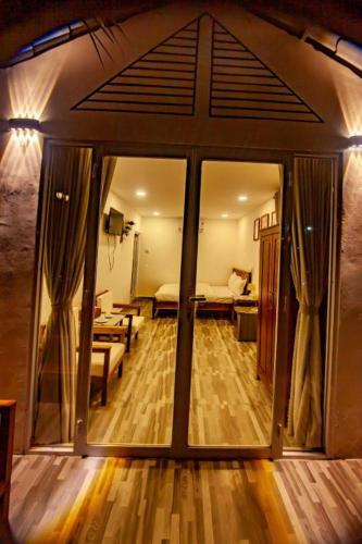 a room with a large glass door with a living room at Hoang Phuc resort in Rạch Giá