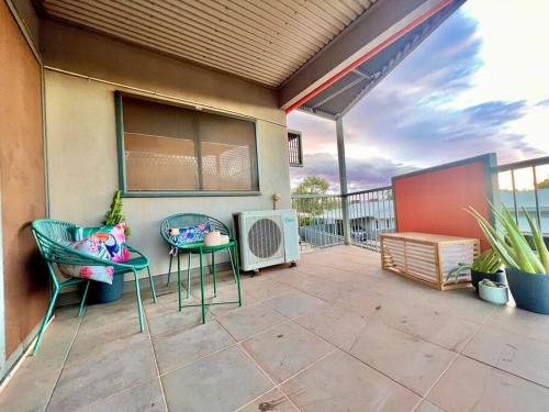 een patio met 2 stoelen, een tafel en verwarming bij Stylish Self-contained Apartment in South Hedland