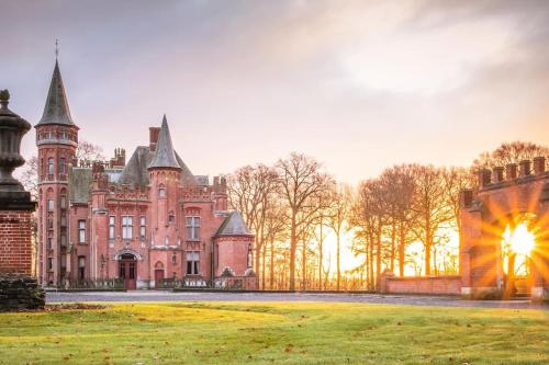 un gran castillo con un campo de hierba delante de él en Castle ten Berghe Château, en Brujas