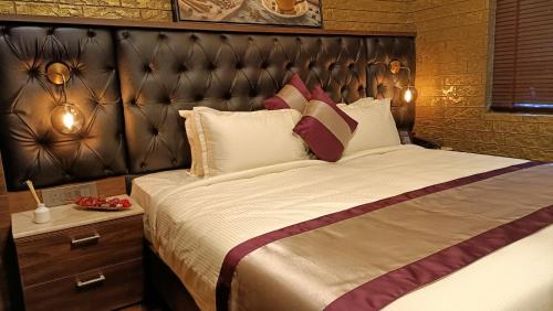 a bedroom with a large bed with a leather headboard at Retrieve Health & Wellness in Cochin