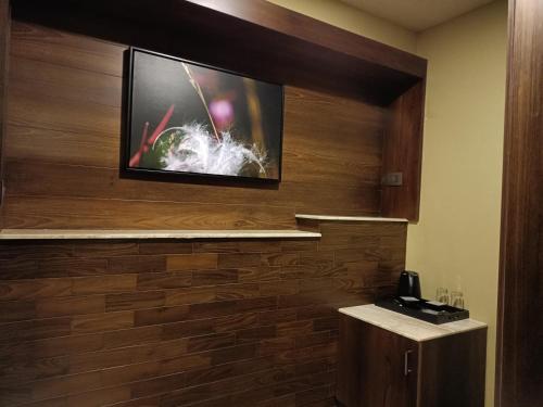 a flat screen tv on a wall in a hotel room at Retrieve Health & Wellness in Cochin