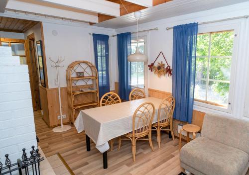 een keuken en eetkamer met een tafel en stoelen bij Tervakosken Tervaniemi hirsimökki & oma sauna in Tervakoski