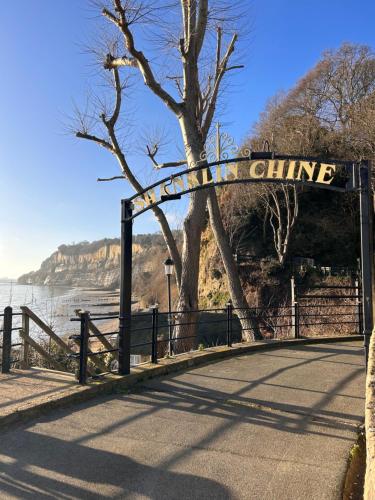 a gate with a sign that reads chine next to a lake at The Bay house Apartments , shanklin in Shanklin