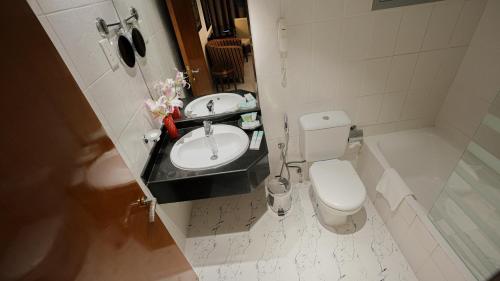 a bathroom with a sink and a toilet at Xclusive Hotel Apartments in Dubai