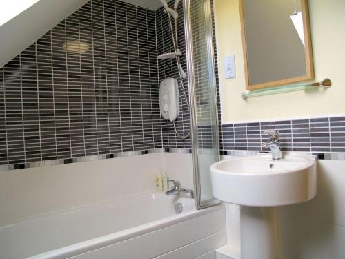 a bathroom with a sink and a mirror and a tub at Croft Mill in Hebden Bridge