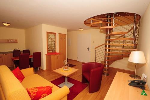 a living room with a couch and a spiral staircase at Kirchenwirt in Maria Schutz in Schottwien