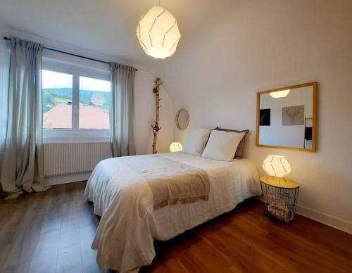 Rooms 6 persons Kaysersberg في كايزرسبرغ: غرفة نوم بسرير ونافذة كبيرة