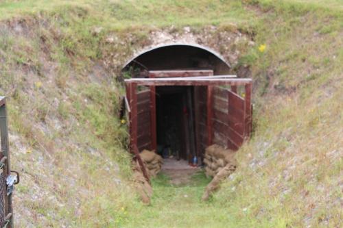 a tunnel in a hill with a red door at 14-18 Somme Chambres in Beaucourt-sur-lʼAncre
