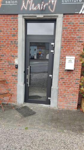 a door in a brick building with a sign on it at Appartement cosy à Chimay in Chimay
