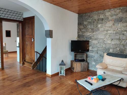 a living room with a couch and a stone wall at Appartement cosy à Chimay in Chimay