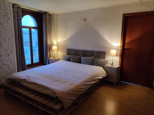 ein Schlafzimmer mit einem großen Bett und zwei Lampen in der Unterkunft Appartement cosy à Chimay in Chimay