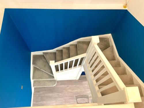a white staircase in a blue room with a ceiling at Fidelity Stays Ocean Themed Luxury Apartment in Brighton & Hove