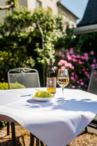 a table with a bottle of wine and a plate of grapes at Rheinhotel Schulz in Unkel