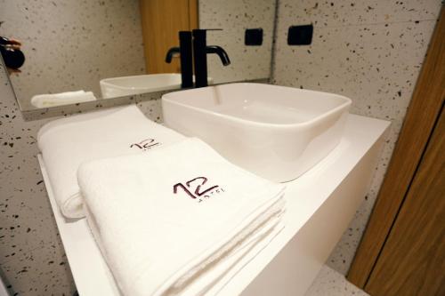 a bathroom with a sink and towels on a counter at HOTEL 12 in Gjakove