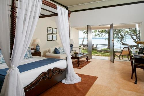 a bedroom with a bed and a view of the ocean at Ekho Lake House in Polonnaruwa