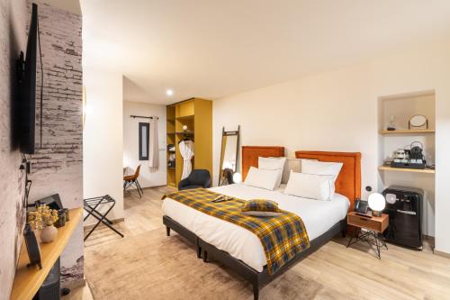 a bedroom with a king sized bed and a living room at Les Jardins de Coppélia in Pennedepie