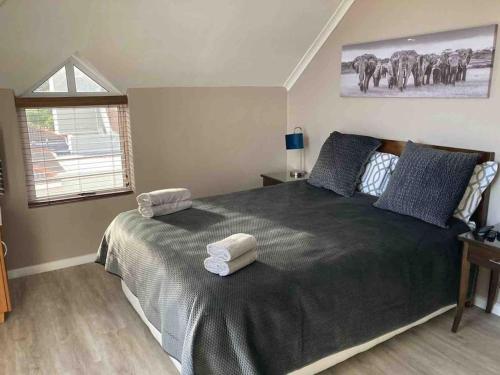 a bedroom with a large bed with two towels on it at Chapman`s Peak, Loft mit Sea-und Mountainview in Hout Bay