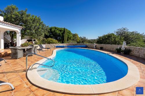 a large blue swimming pool on a patio at Casa Carob in Lagoa