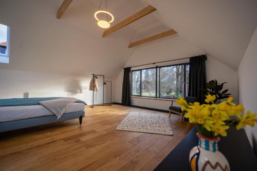 ein Schlafzimmer mit einem Bett und einer Vase mit gelben Blumen in der Unterkunft Modernes Ferien- und Messezimmer in idyllischer Lage in Nordstemmen