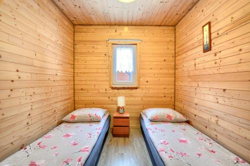 a room with two beds in a log cabin at U Źródeł Strwiąża in Ustrzyki Dolne