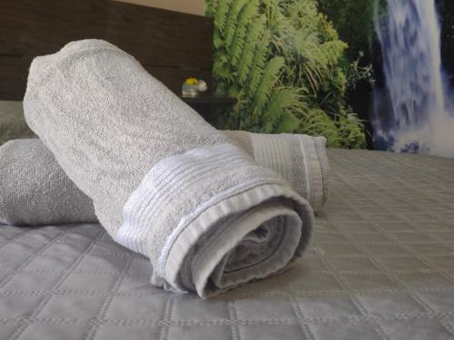 a rolled up towel on top of a bed at Casa com Piscina e 3 Quartos Climatizados 8km do Centro in Palmas