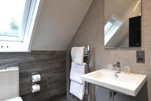a bathroom with a sink and a mirror at The Beach House Loch Lomond in Luss