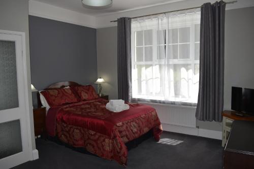 a bedroom with a red bed and a window at Moorlands in Parracombe