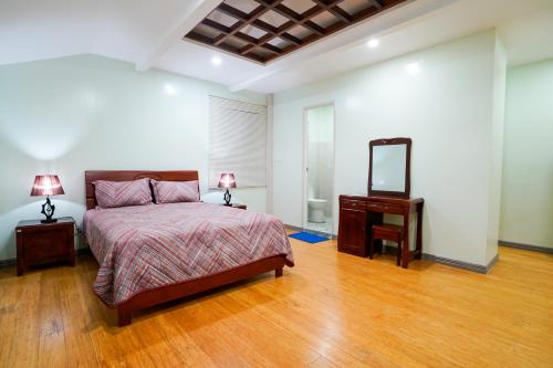 a bedroom with a bed and a dresser and a mirror at MS Mountain Cabin in Loboc