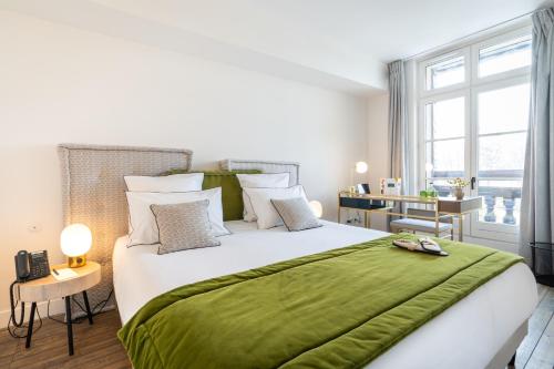 a bedroom with a large bed with a green blanket at Les Jardins de Coppélia in Pennedepie