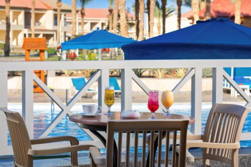 a table with two chairs and two drinks on a balcony at Pickalbatros Aqua Blu Sharm El Sheikh in Sharm El Sheikh