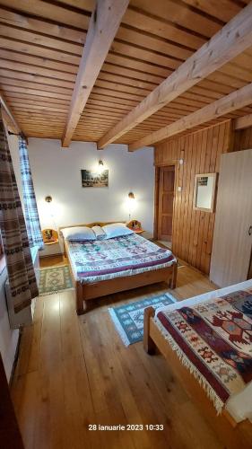 a bedroom with two beds and a wooden ceiling at Pensiunea DANA in Predeal