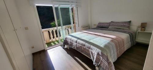 a bedroom with a bed and a large window at Casa en Alella, Barcelona in Alella