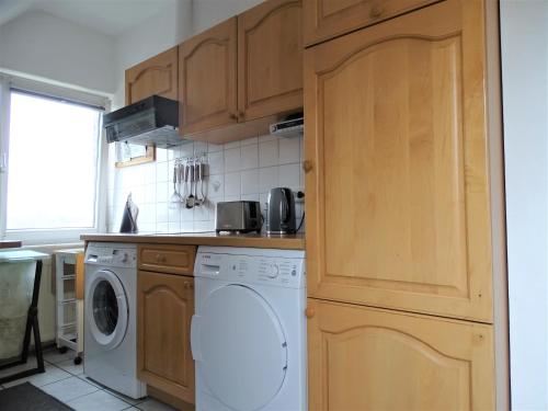 a kitchen with a washer and dryer at Helle Ferienwohnung in Nettetal bei Venlo in Nettetal