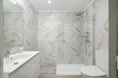 un bagno bianco con doccia e WC di Apartamento Algarve, located center of Vilamoura a Quarteira