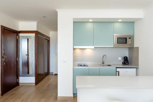 a kitchen with blue cabinets and a counter top at Apartamento Algarve, located center of Vilamoura in Quarteira