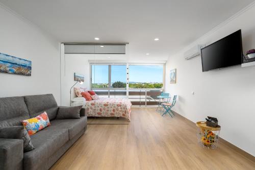 a living room with a couch and a bedroom at Apartamento Algarve, located center of Vilamoura in Quarteira