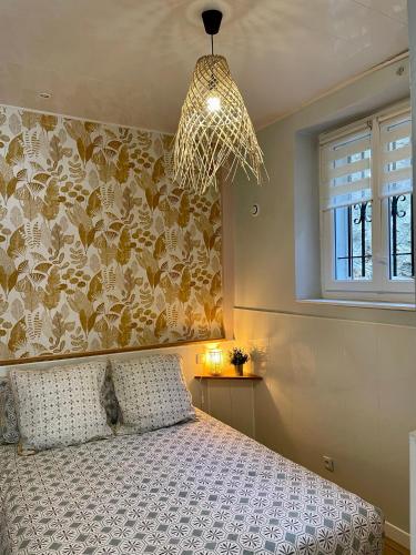 une chambre avec un lit et un lustre dans l'établissement Appartement à louer, Bandol, à Bandol
