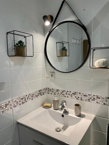 une salle de bain blanche avec un lavabo et un miroir dans l'établissement Appartement à louer, Bandol, à Bandol