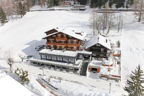 a large building covered in snow in the snow at Hotel Restaurant Waldhaus in Leukerbad