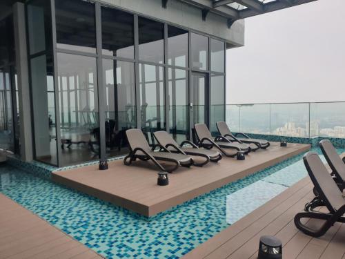 a swimming pool with a row of chairs in a building at EkoCheras Duplex Suite by Ohana Home in Kuala Lumpur