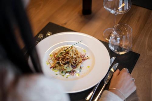 a person sitting at a table with a plate of food at Hotel Niblea Dolomites in Ortisei